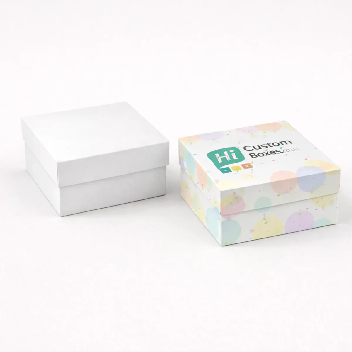Two square rigid gift boxes- one plain white and one decorated with colourful pastel dots- class=